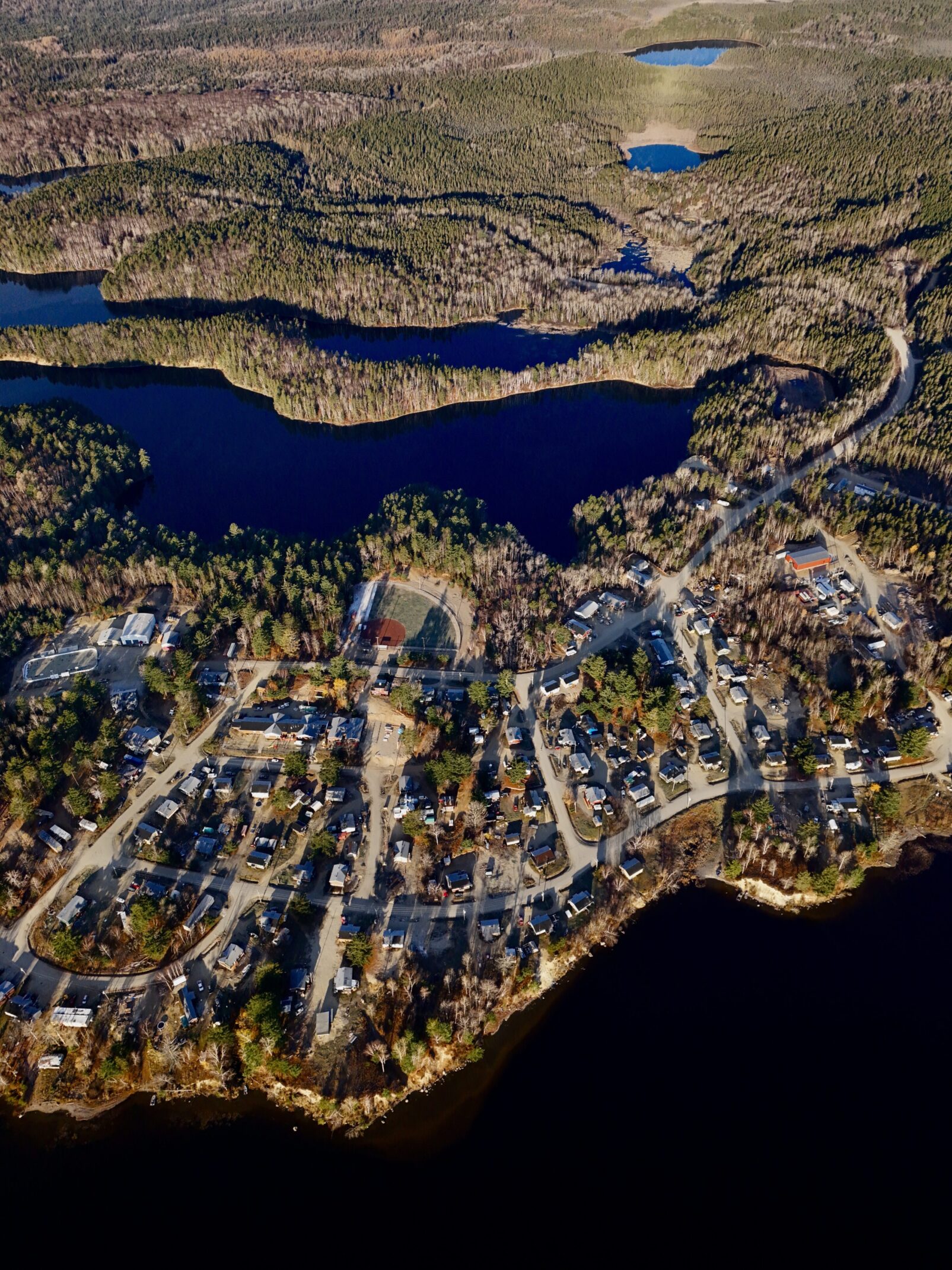 Aerial view of a coastal town with houses and water bodies.